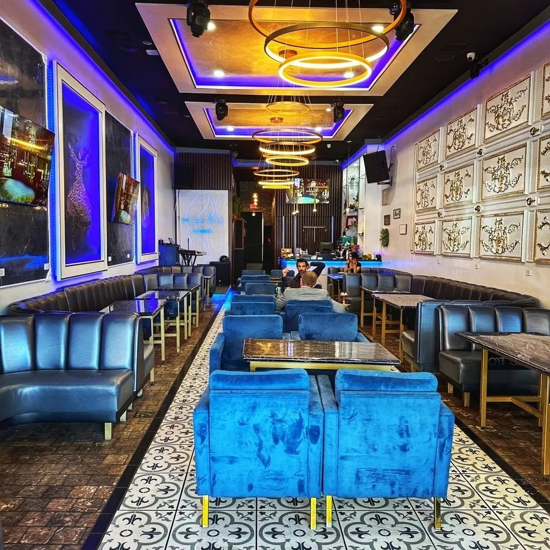 Maestro Lounge dining room with blue seating, framed art and glowing ring lights