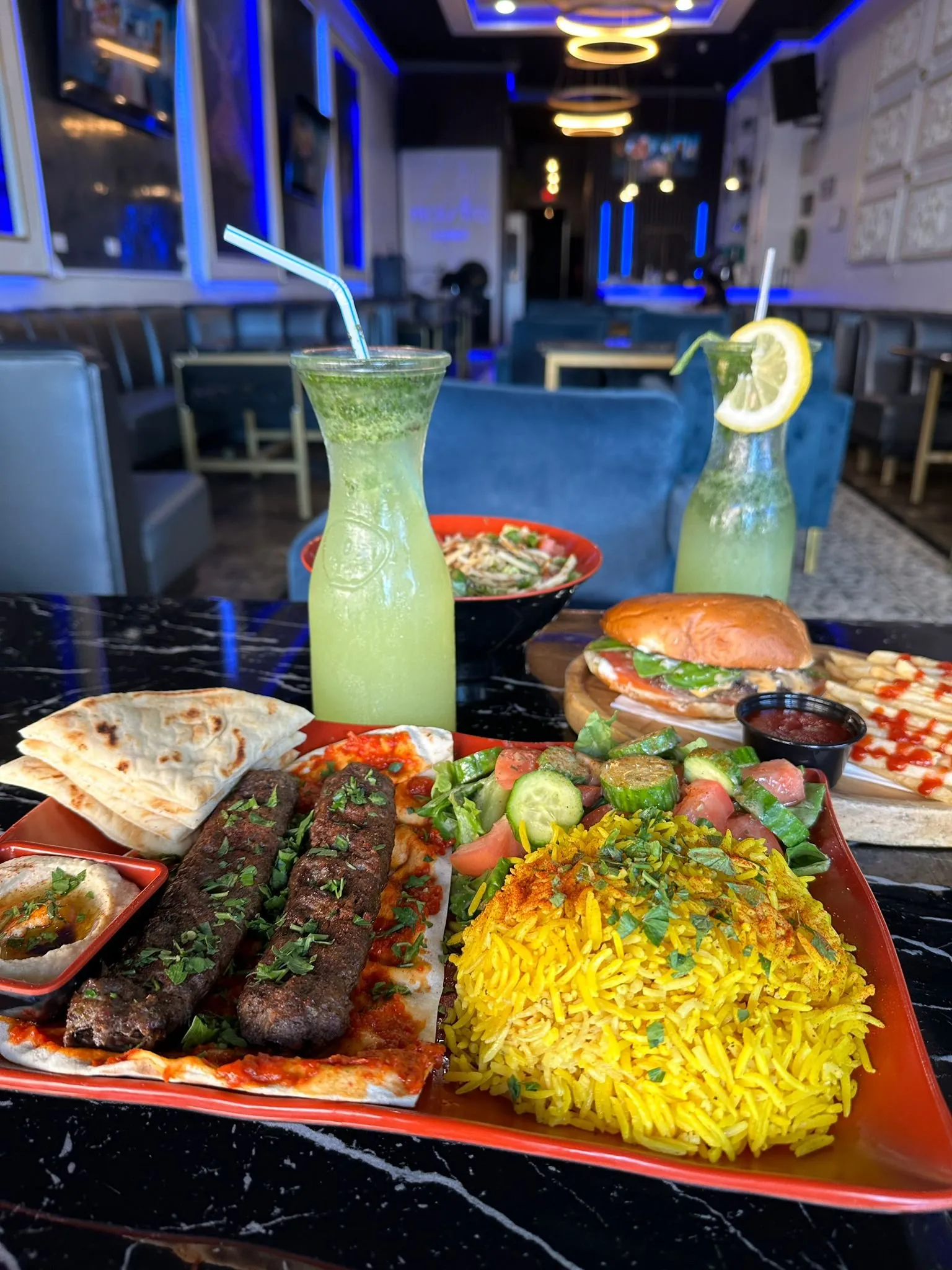 Green juices, grilled kebab, burger, pita, rice and salad served at Maestro Lounge