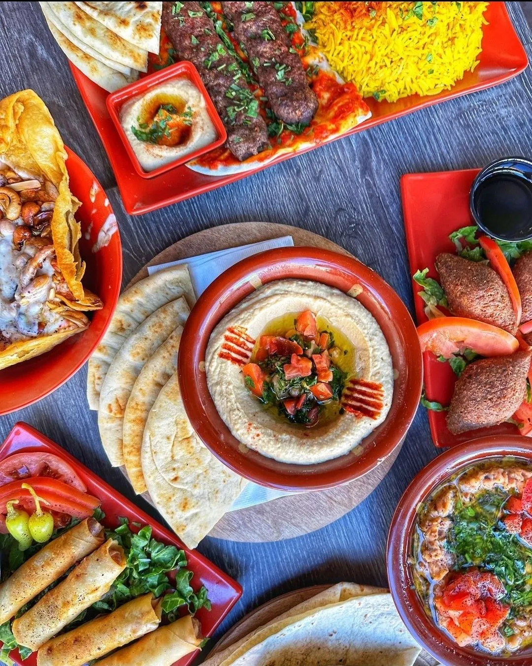 Overhead Maestro spread with hummus, mixed grill, rice, falafel and spring rolls